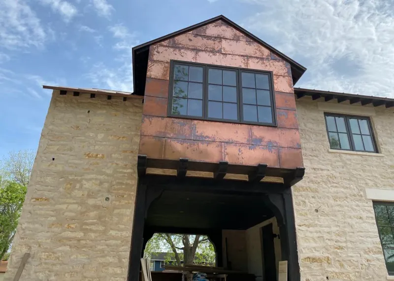Copper metal panel facade on a stone building for Roof Repair in Rose Hill